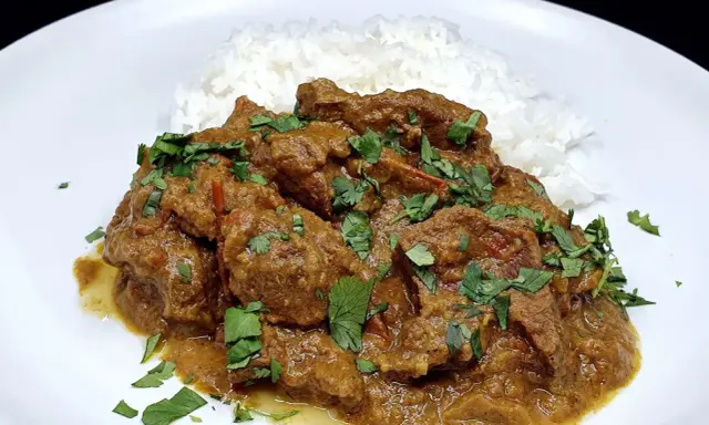 Un savoureux curry d'agneau, mijoté et garni de coriandre fraîche, servi avec du riz blanc.