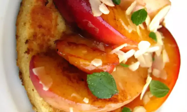 Tranches de fruits grillés sur pain toasté, garnies d'amandes effilées et de menthe.