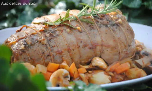 Un rôti d'agneau à la cocotte en fonte, savamment lié et garni de romarin, entouré de légumes rôtis.
