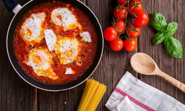 Œufs pochés dans une sauce tomate savoureuse, rappelant la sauce armoricaine, avec des tomates fraîches et du basilic.