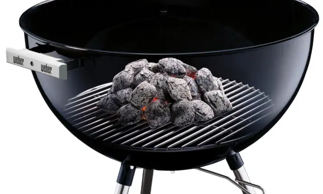 Grille foyère barbecue Weber avec charbon ardent. Elle sert à cuire vos aliments à la perfection.