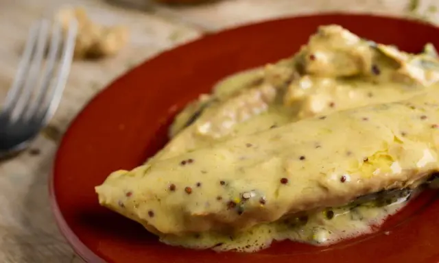 Poisson nappé d'une onctueuse sauce moutarde, servi sur une assiette rouge. Un délice !