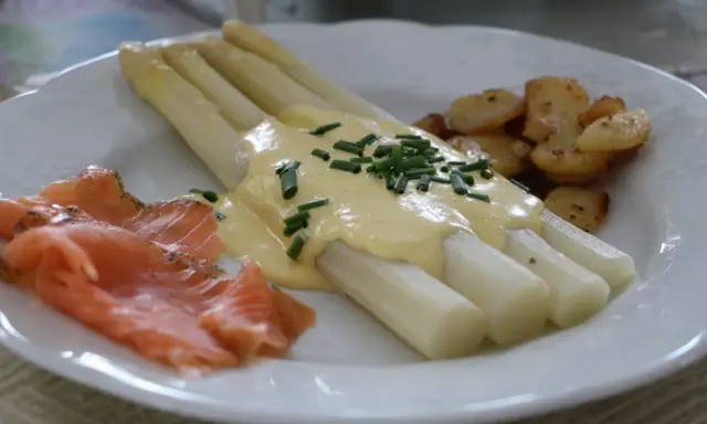 Asperges blanches nappées de sauce hollandaise, accompagnées de saumon fumé et de pommes de terre sautées. Un délice !