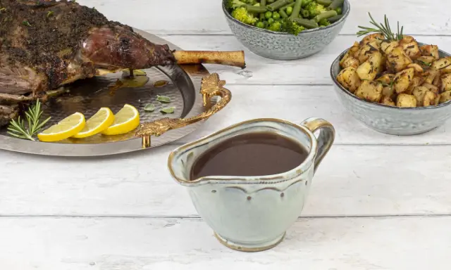 Sauce onctueuse pour accompagner une tranche de gigot d'agneau, avec des pommes de terre rôties et des légumes verts.