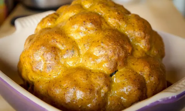Un chou-fleur entier, doré et appétissant, prêt à être dégusté. Ce chou-fleur barbecue a une belle croûte caramélisée.