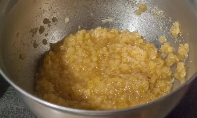 Un bol en métal contient une purée de lentilles corail, prête à être cuisinée.
