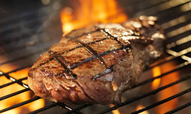 Un délicieux faux filet barbecue, marqué par les flammes, cuit à la perfection sur un grill.