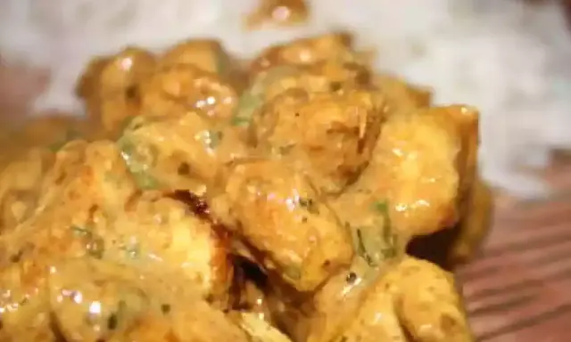 Délicieux poulet tikka en sauce crémeuse, servi avec du riz blanc. Un plat savoureux et réconfortant.