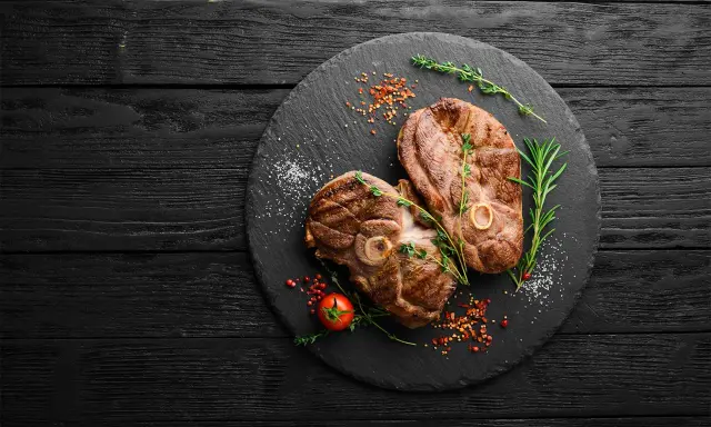 Deux belles tranches de gigot d'agneau au barbecue, parfaites pour un repas savoureux. Le temps de cuisson idéal pour cette viande tendre.