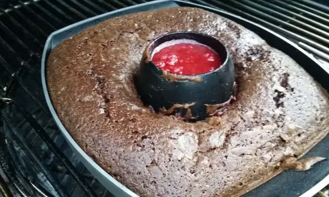 Gâteau au barbecue, un délice chocolaté avec un cœur de coulis de fruits rouges, prêt à être dégusté.
