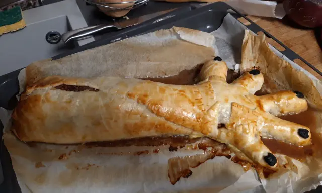 Un plat d'Halloween effrayant : une main de viande en croûte dorée, prête à saisir les gourmands.