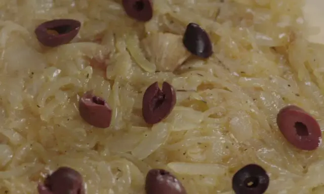 Un délice de confit d'oignon, parsemé d'olives noires, prêt à être dégusté.