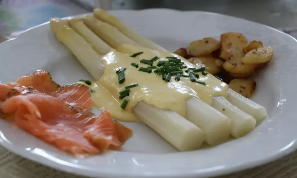 Asperges blanches nappées de sauce hollandaise, accompagnées de saumon fumé et de pommes de terre sautées. Un délice !