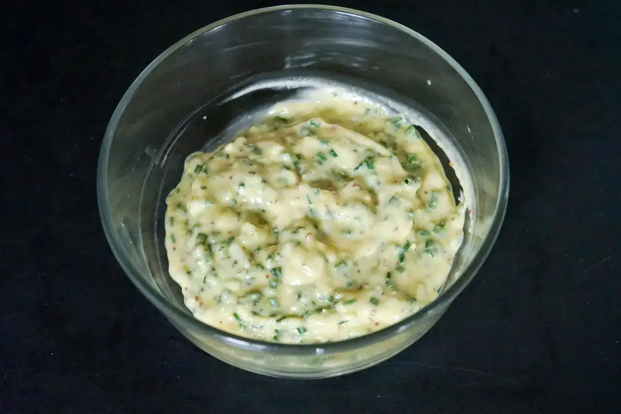 Sauce tartare crémeuse avec des herbes fraîches et des petits morceaux, prête à accompagner vos plats.