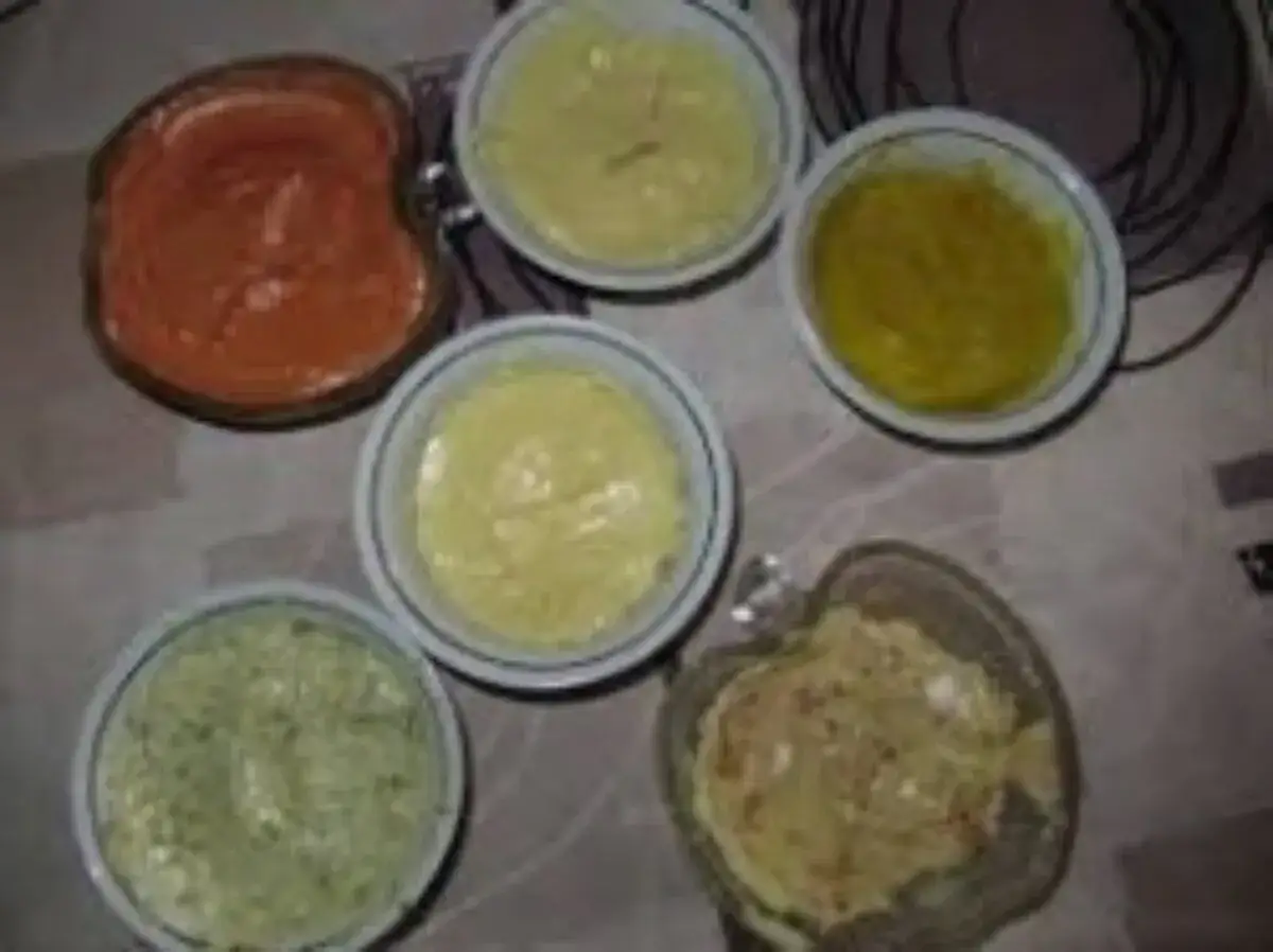 Six sauces variées pour une pierrade : une rouge, deux jaunes, une verte et deux autres.
