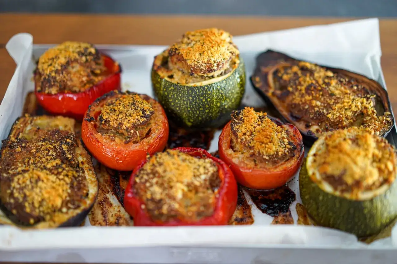 Assortiment de légumes farcis : tomates, courgettes rondes et aubergines, gratinés avec une chapelure dorée. Un délice !
