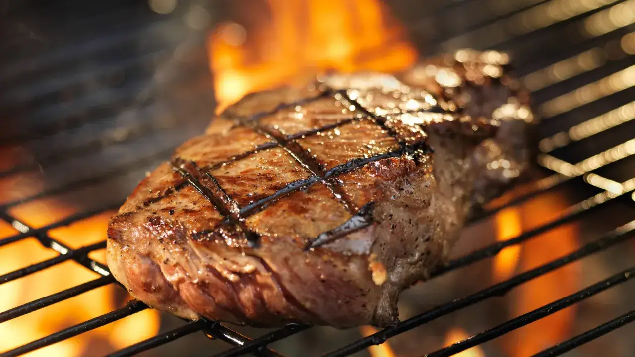 Un délicieux faux filet barbecue, marqué par les flammes, cuit à la perfection sur un gril.