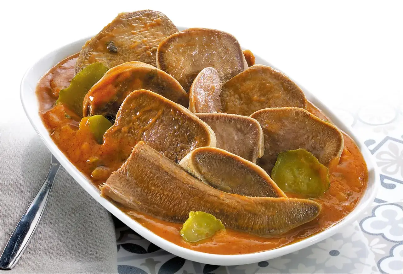 Tranches de langue de bœuf tendres et savoureuses, mijotées dans une sauce riche et accompagnées de légumes verts. Un plat réconfortant.