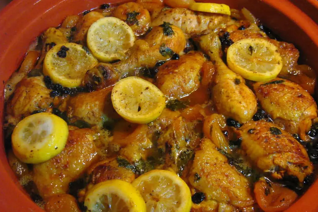 Un plat de tajine poulet aux citrons confits et olives, mijoté dans une sauce dorée.