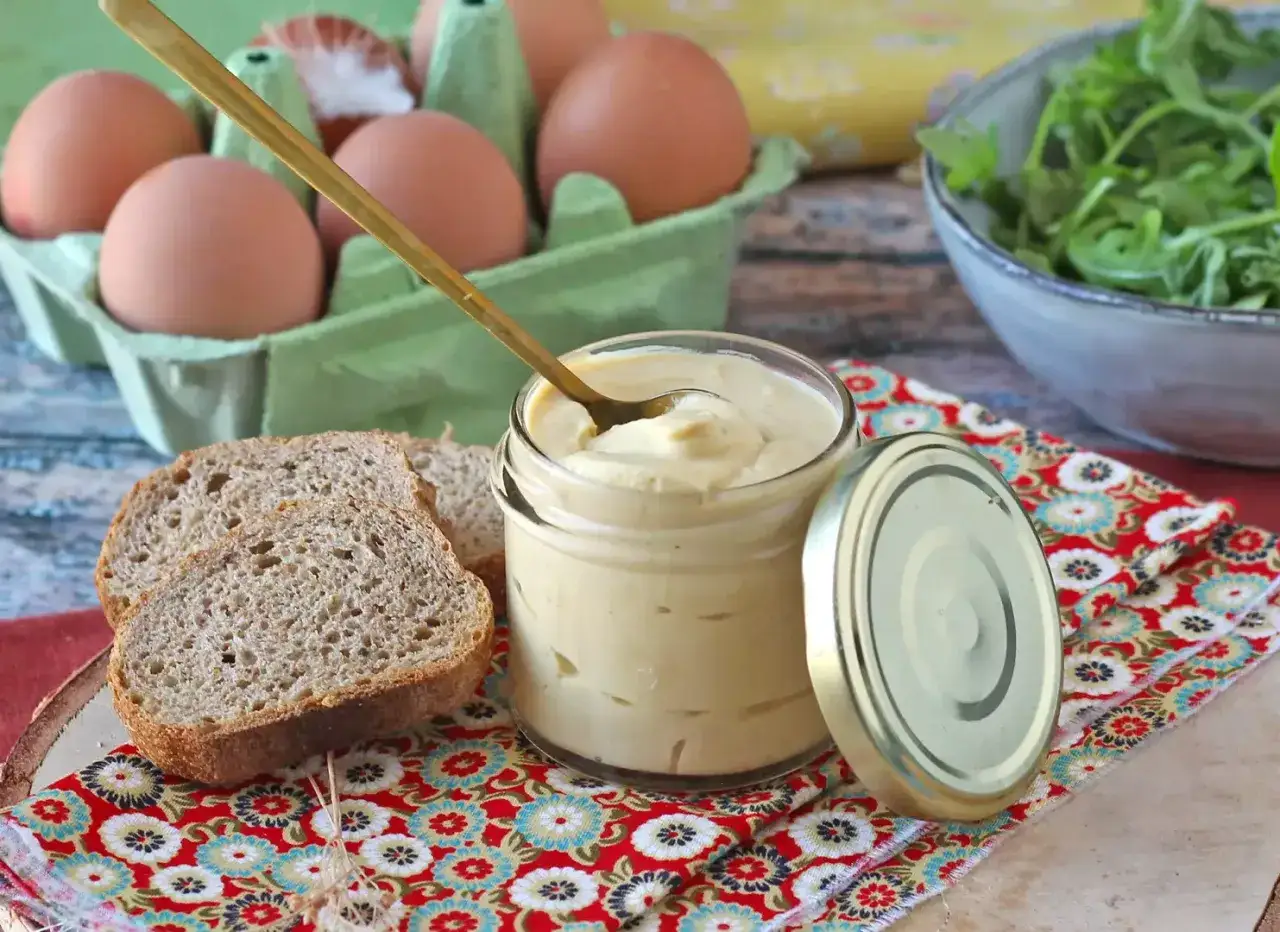 Un pot de mayonnaise sans huile, des tranches de pain complet, des œufs et de la roquette.