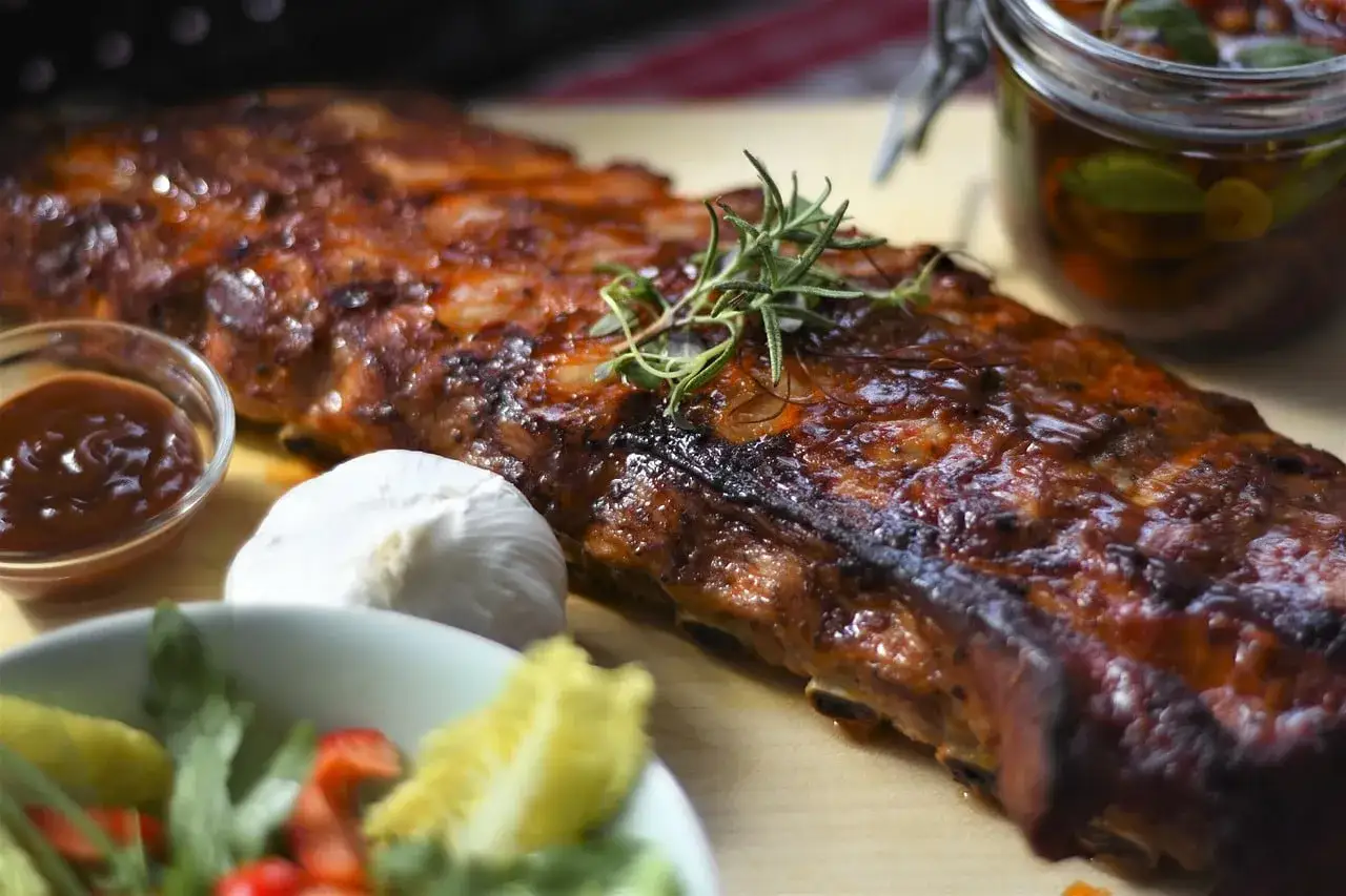 Travers de porc au barbecue Weber, sauce barbecue, ail, herbes fraîches. Parfait pour le temps de cuisson idéal.