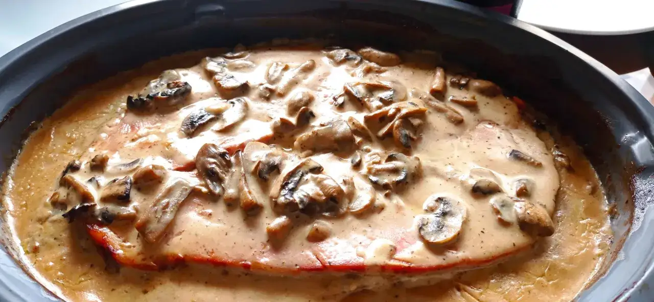 Un plat de viande généreux nappé d'une onctueuse sauce madère aux champignons, prêt à être dégusté.