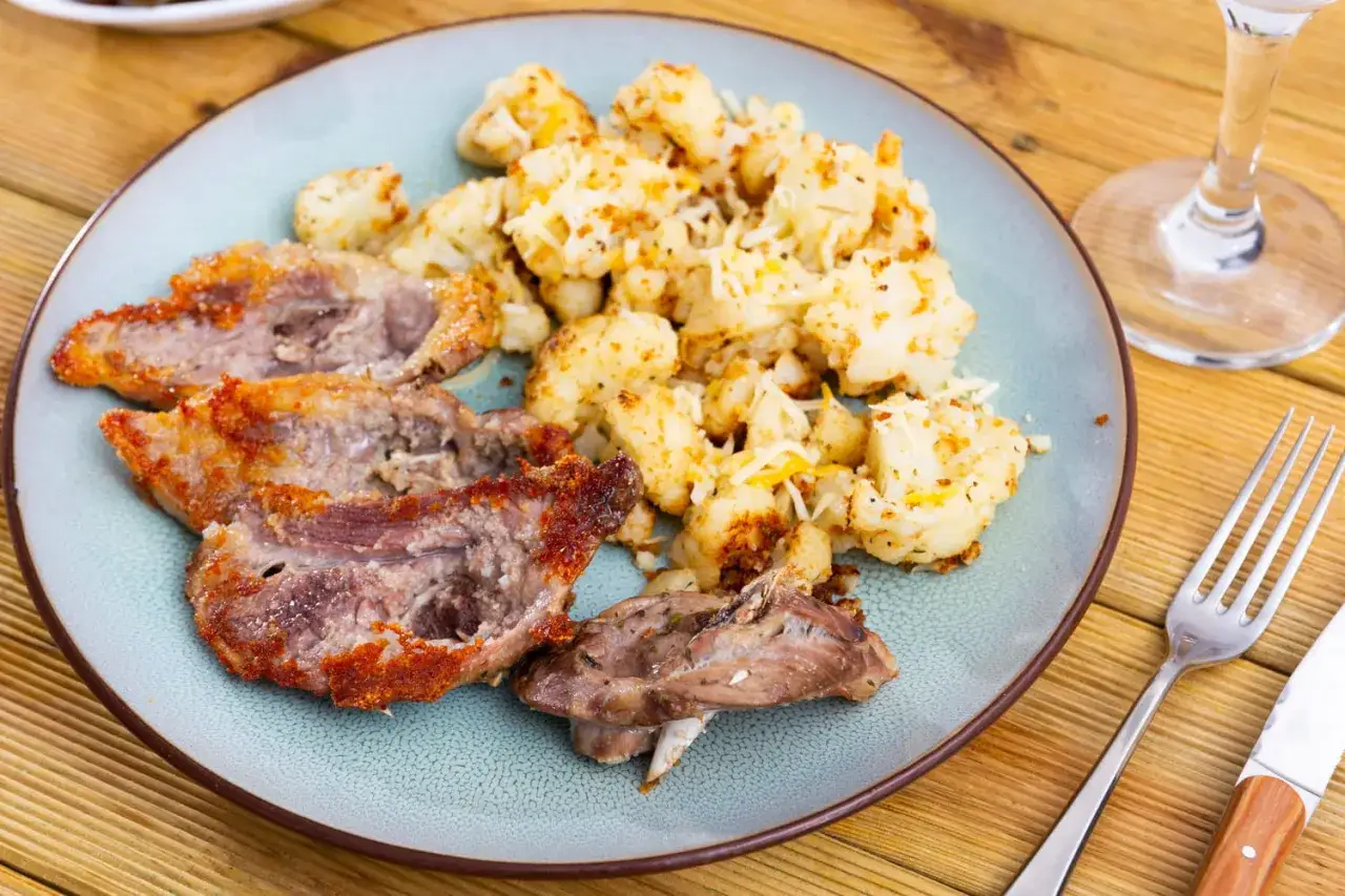 Délicieux morceaux de gigot d'agneau poêlés, accompagnés de chou-fleur rôti et de fromage râpé. Une idée parfaite pour savoir que faire avec des morceaux de gigot d'agneau.