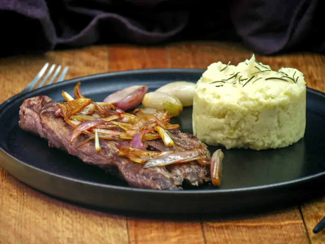 Une bavette à l'échalote savoureuse, accompagnée d'une purée de pommes de terre crémeuse et de quelques échalotes rôties. Un délice !