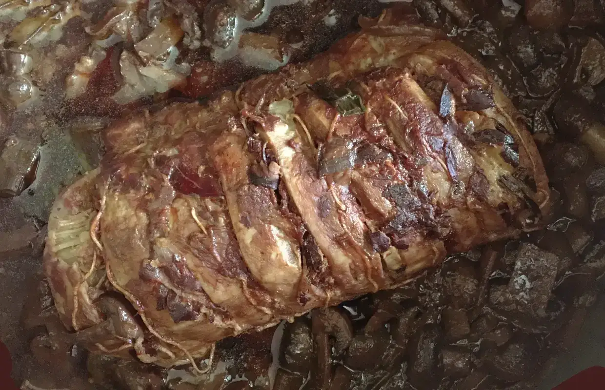 Un rôti de porc mijote dans une sauce brune, prêt à être effiloché. Les fibres tendres promettent un délice.