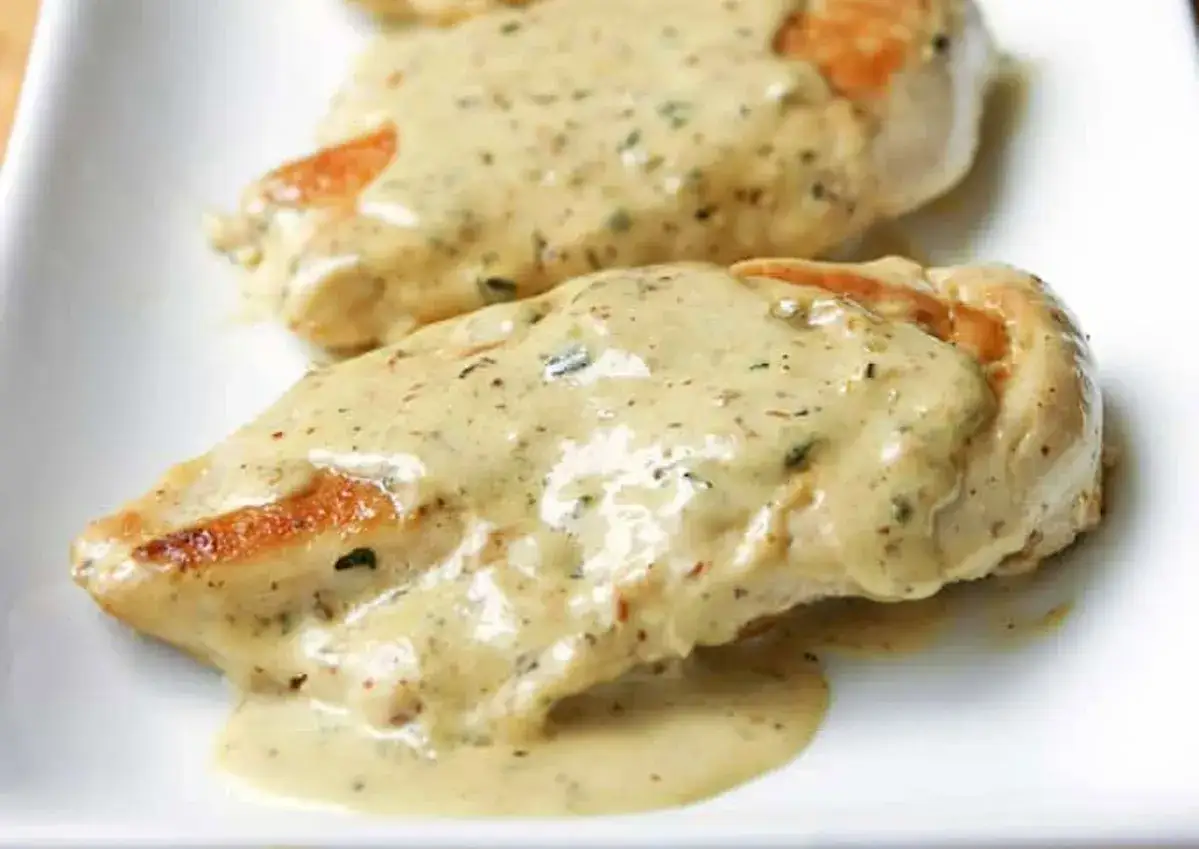 Deux poitrines de poulet nappées d'une sauce crémeuse et épicée, rappelant le butter chicken.