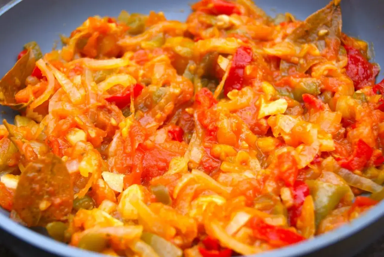 Poêlée de poivrons, tomates et oignons, prête pour une délicieuse piperade recette.