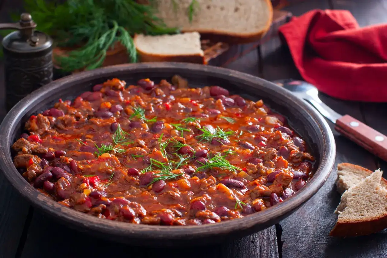 Un plat de haricots rouges mijotés avec de la viande et des épices, garni d'aneth. Une excellente recette haricot rouge pour un repas réconfortant.