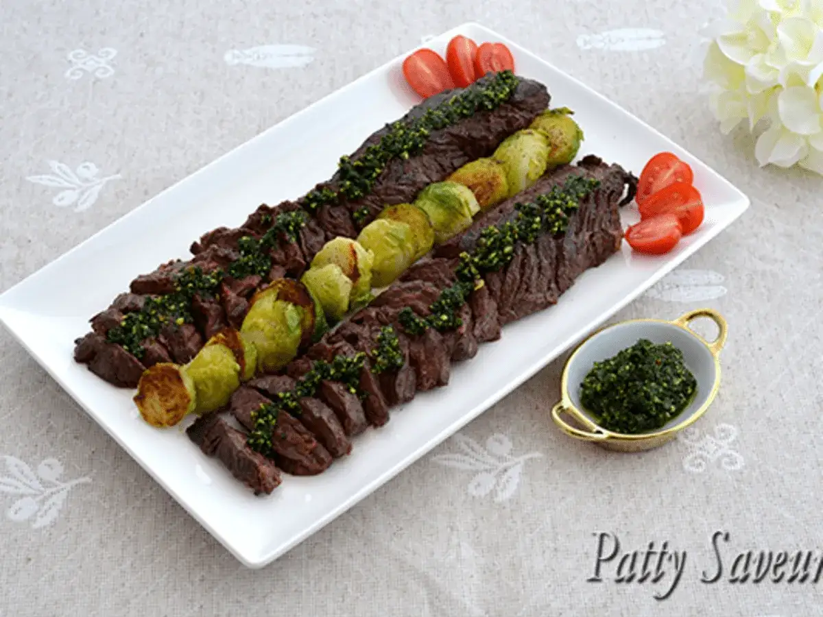 Délicieuses brochettes de viande grillée, garnies de pesto frais et accompagnées de choux de Bruxelles rôtis. Quelle viande avec du pesto, un plat savoureux !