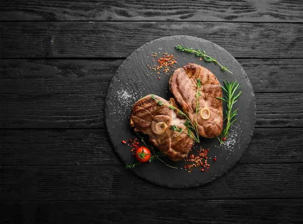 Deux belles tranches de gigot d'agneau au barbecue, parfaites pour un repas savoureux. Le temps de cuisson idéal pour cette viande tendre.