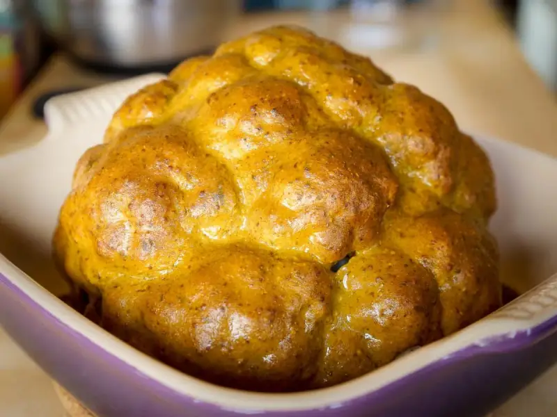 Un chou-fleur entier, doré et appétissant, prêt à être dégusté. Ce chou-fleur barbecue a une belle croûte caramélisée.